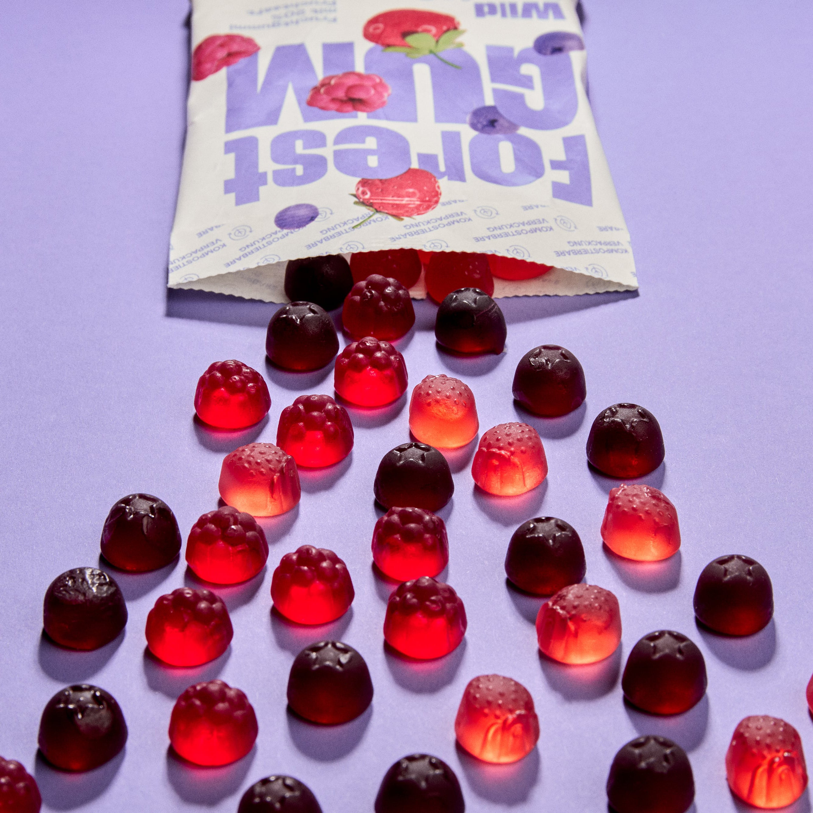 vegane Fruchtgummis in Form von Erdbeeren, Blaubeeren & Himbeeren, fallen aus kompostierbarer Verpackung.