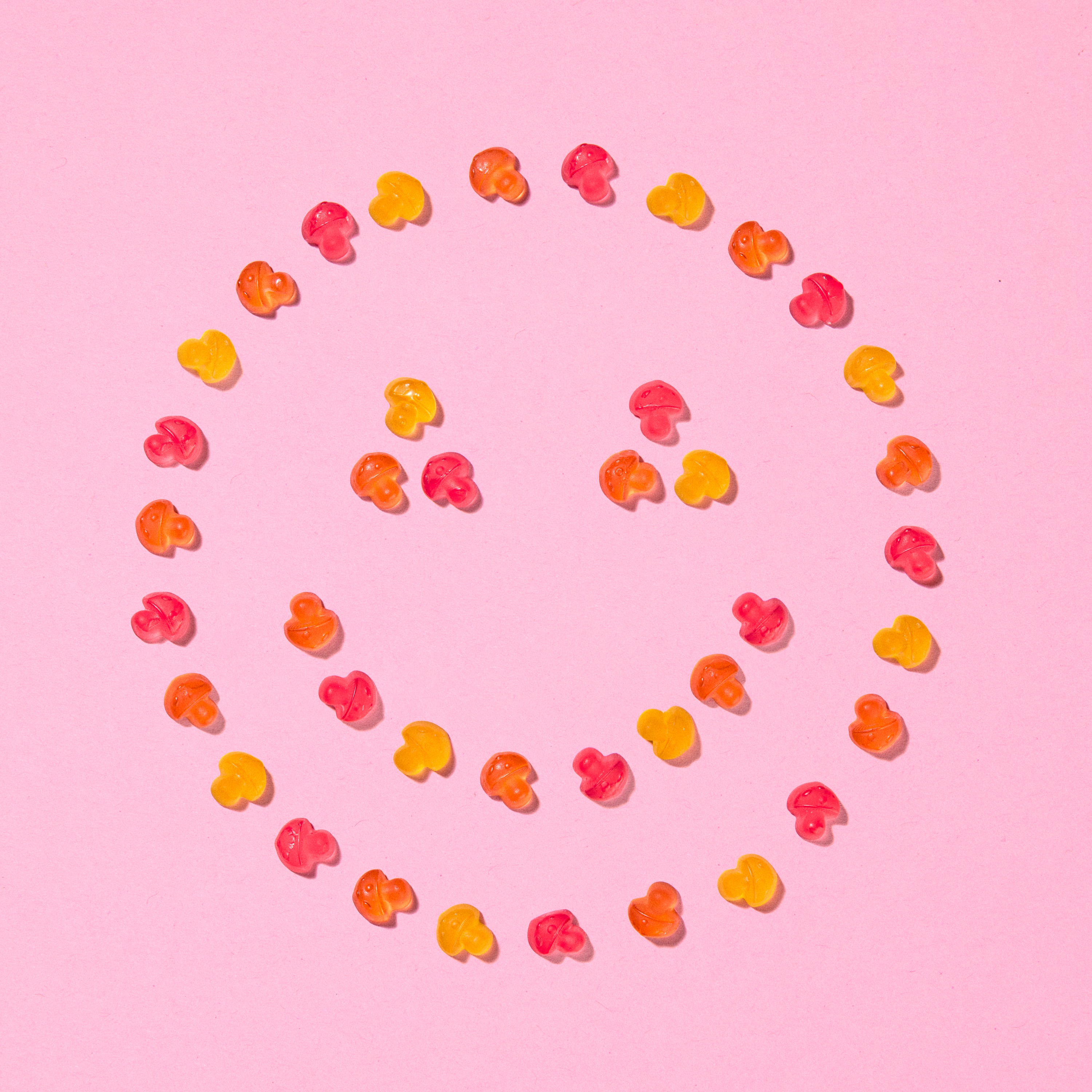 Forest Gum Magic Mushrooms vegane Fruchtgummis in Pilzform, von oben als Smiley-Gesicht angeordnet.